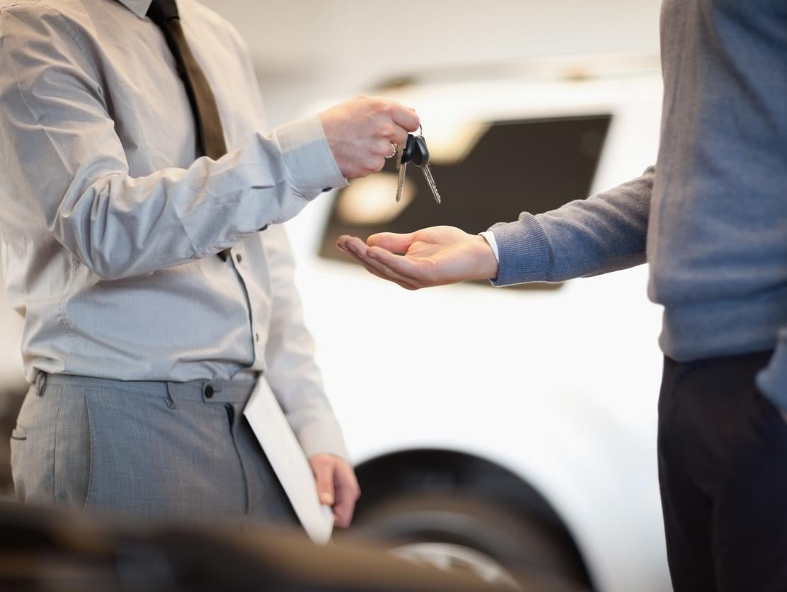 image of a person handing over a car key to another person